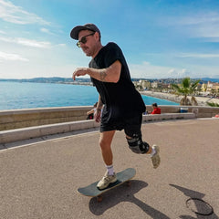 Man skateboarding by a waterfront with a scenic view wearing grey knee brace - Z1 Knee Brace